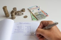 © magele-picture - stock.adobe.com Person schreibt in Haushaltsbuch