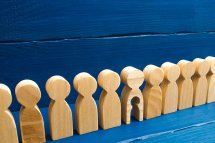© Andrii Yalanskyi - stock.adobe.com Holzfiguren in einer Reihe, eine hat ein ausgeschnittenes Kind