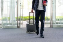 Mann mit Koffer am Flughafen