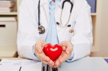 Arzt mit Herzsymbol in Händen